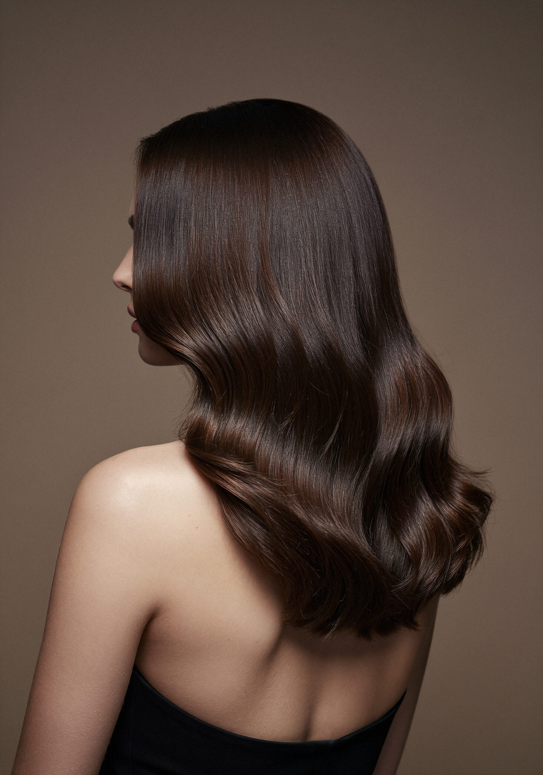 woman-with-long-wavy-shiny-dark-hair-bare-shoulders